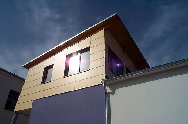 Mit Platten verkleidete Fassade eines modernen Gebäudes bei Abendlicht