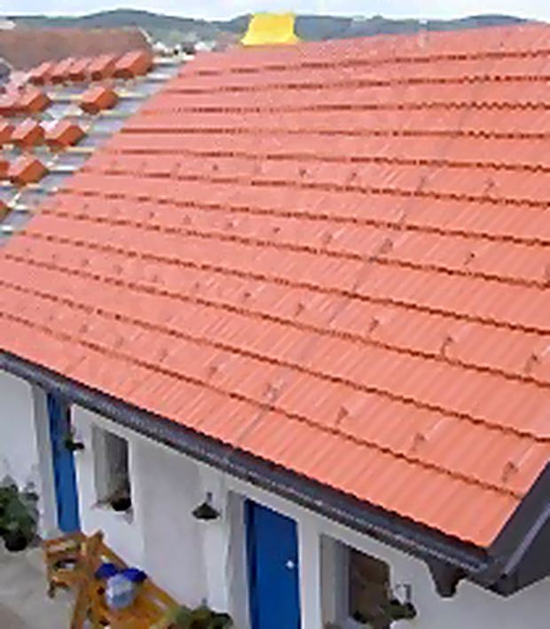 Neu eingedecktes Ziegeldach über einem Wohnhaus